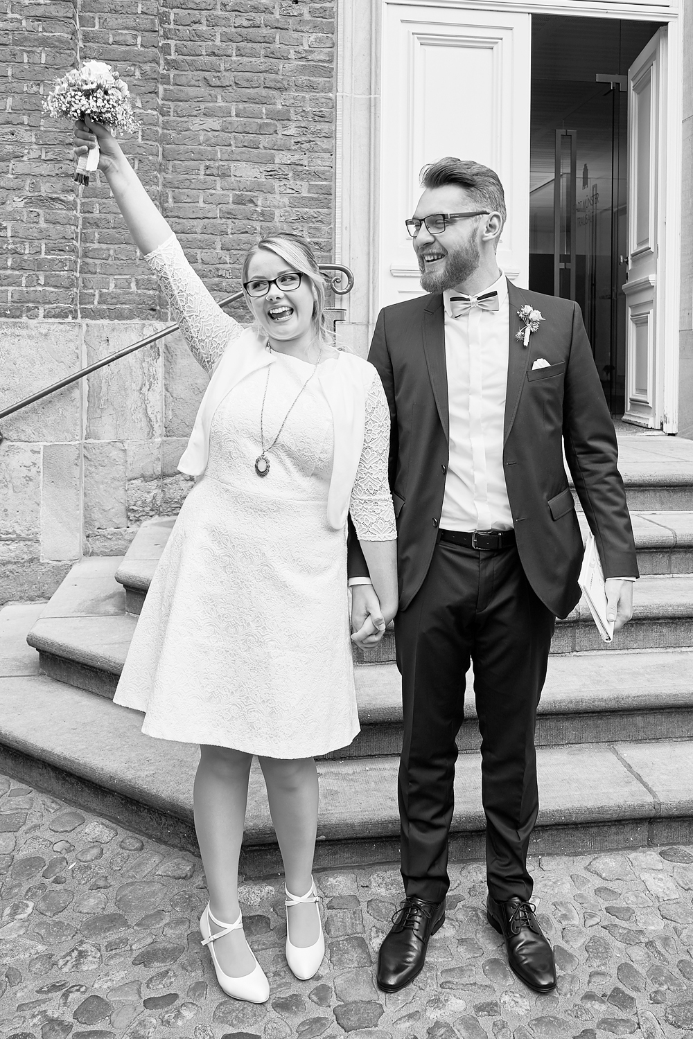 glückliches Hochzeitspaar vor dem Standesamt in Münster fotografiert von Birgit Giering der Lichtgestalterin Hochzeitsfotografin aus Münster